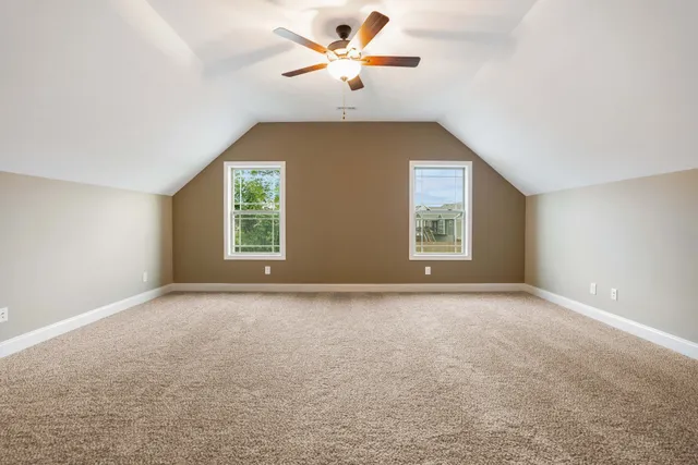 an empty room with windows and a ceiling fan