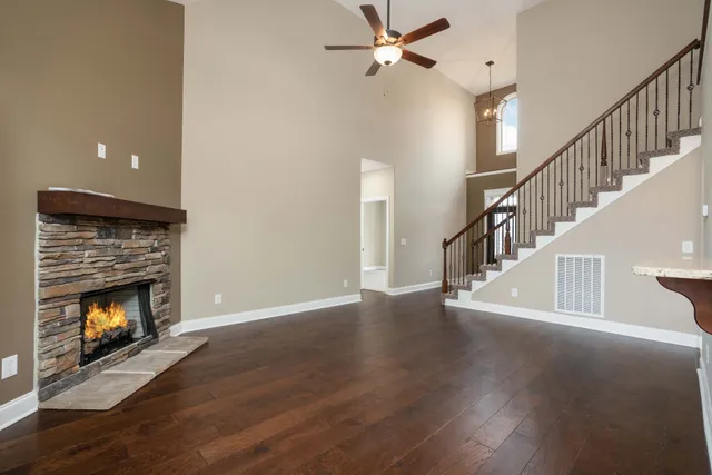 a view of an empty room with wooden floor fireplace and a fire place