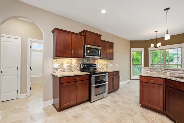 a kitchen with stainless steel appliances granite countertop a stove sink and microwave
