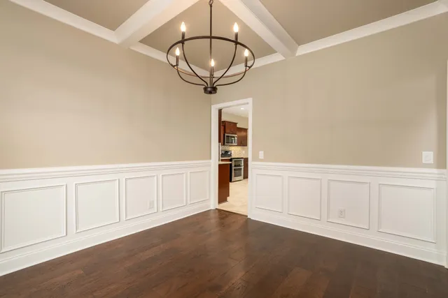 an empty room with chandelier fan