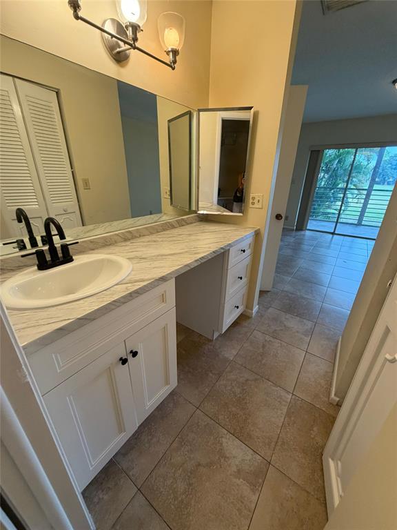 7410 Woodmont Terrace, Unit 207 Tamarac, FL 33321 - Photo 16 of 20 a bathroom with a double vanity sink and mirror