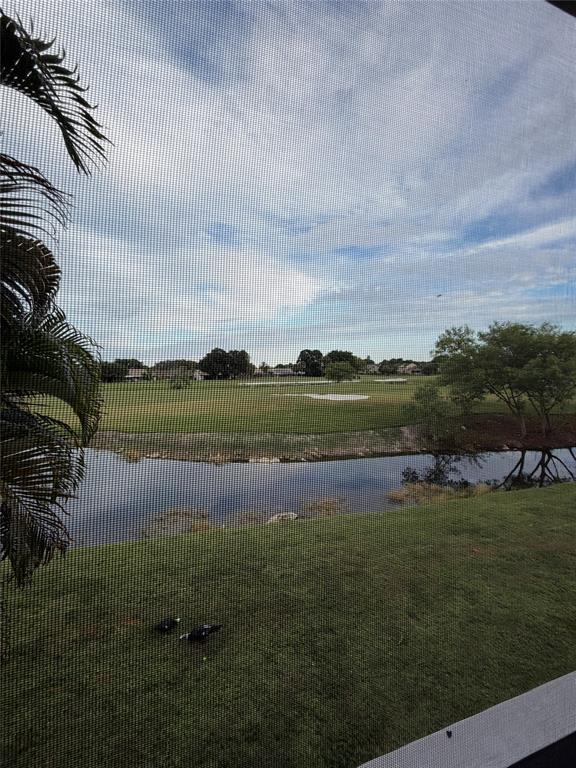 7410 Woodmont Terrace, Unit 207 Tamarac, FL 33321 - Photo 19 of 20 a view of a lake with houses in the background