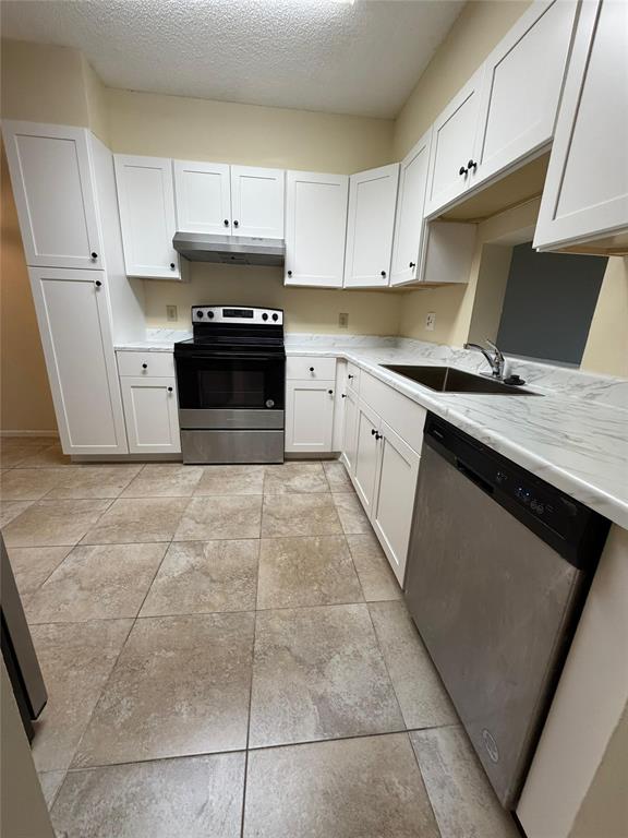 7410 Woodmont Terrace, Unit 207 Tamarac, FL 33321 - Photo 2 of 20 a kitchen with stainless steel appliances granite countertop a stove a sink and a microwave
