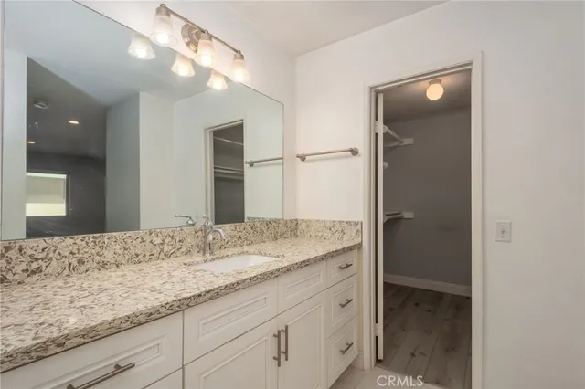 a bathroom with a granite countertop sink and a mirror