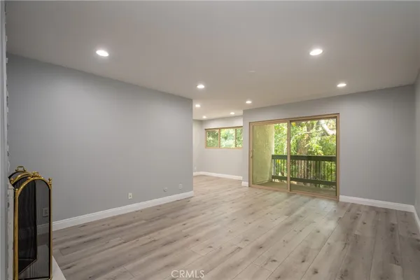 an empty room with wooden floor and a window