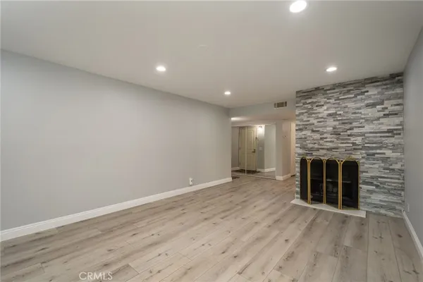 an empty room with wooden floor and fireplace