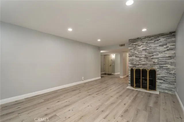 an empty room with wooden floor and fireplace