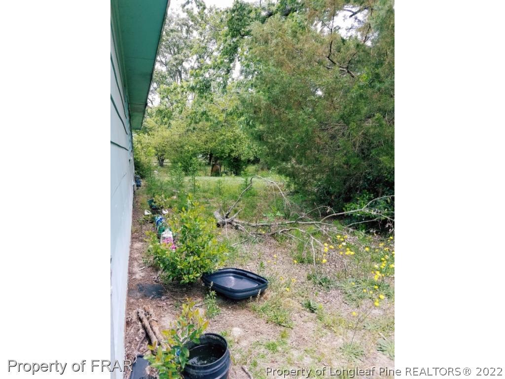3913 Cumberland Road Fayetteville, NC 28306 - Photo 13 of 13 a backyard of a house with lots of green space