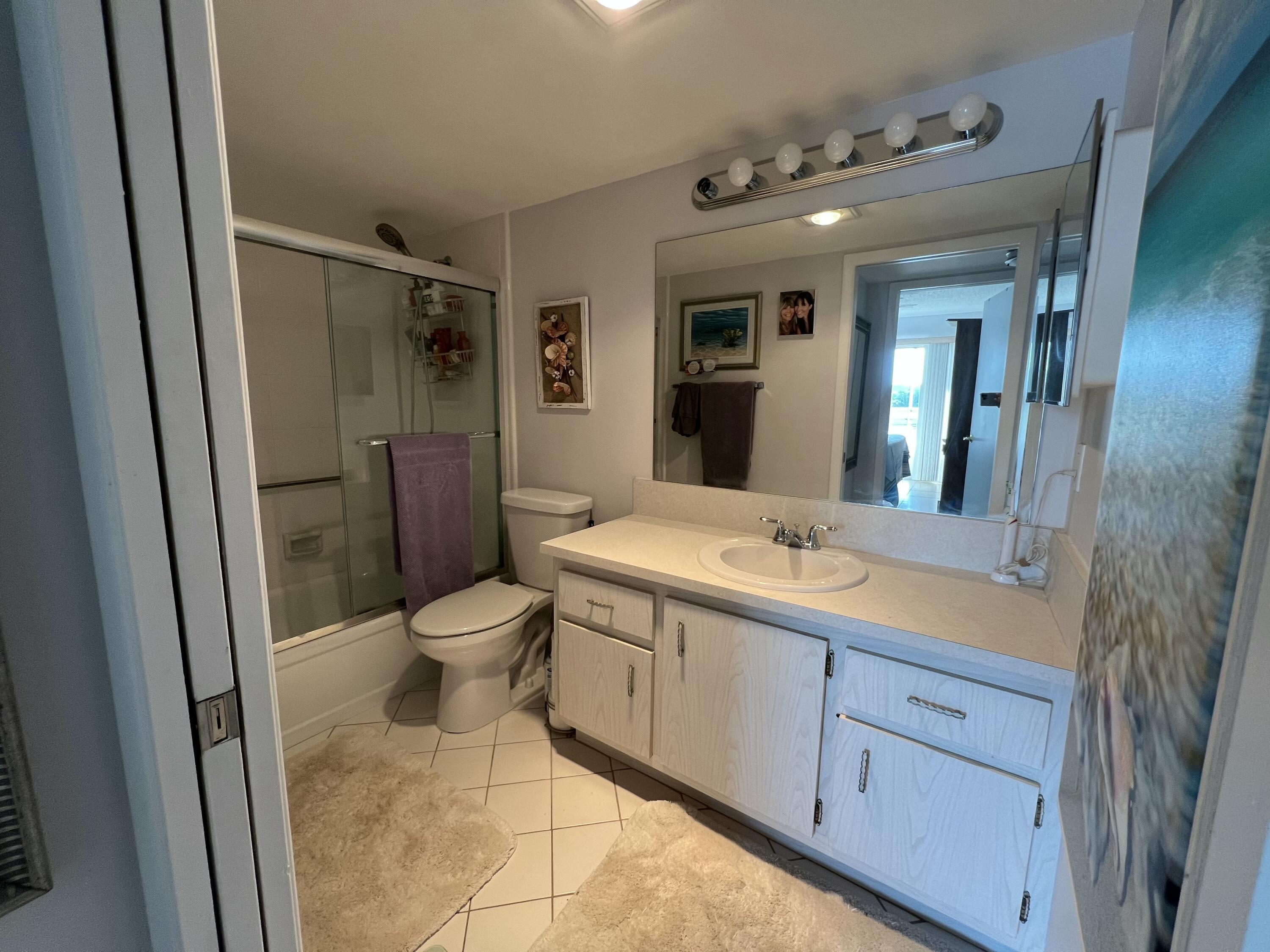 2038 Hythe A Boca Raton, FL 33434 - Photo 15 of 15 a spacious bathroom with a granite countertop sink toilet a mirror and shower
