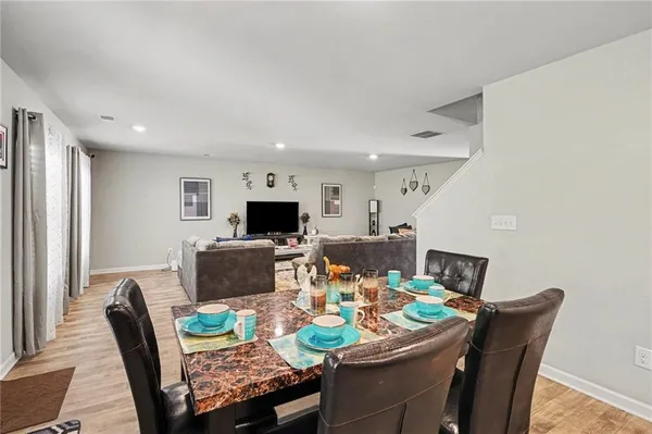 a kitchen with a dining table chairs and refrigerator