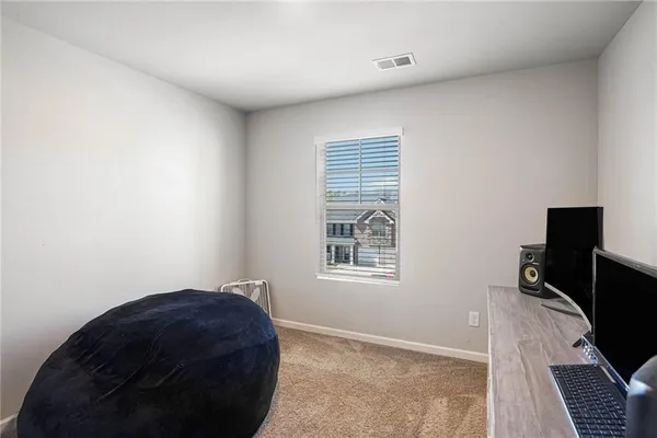a bedroom with a bed and a flat tv screen on the dresser