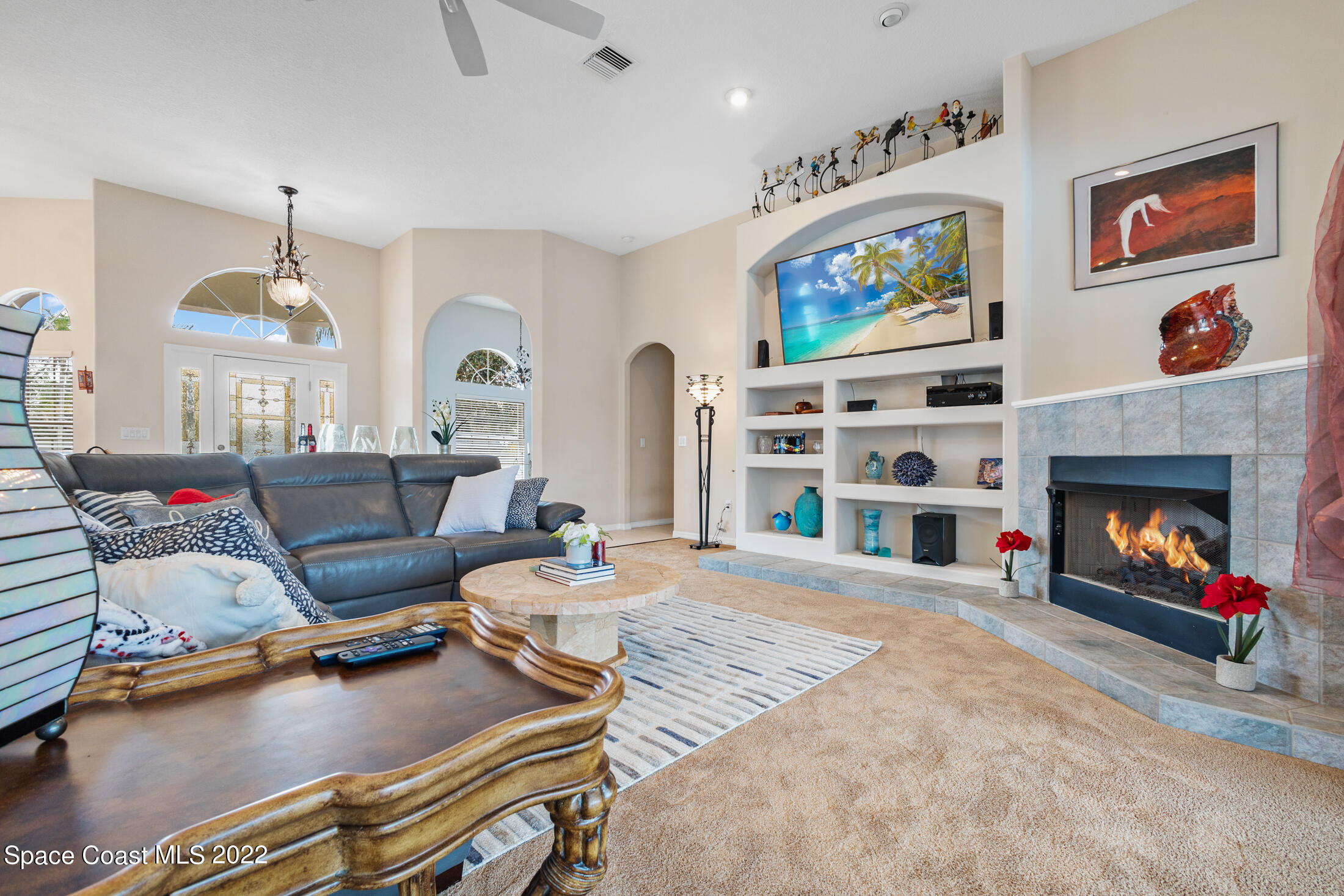 3650 Shady Run Road Melbourne, FL 32934 - Photo 8 of 43 a living room with furniture a fireplace and a flat screen tv