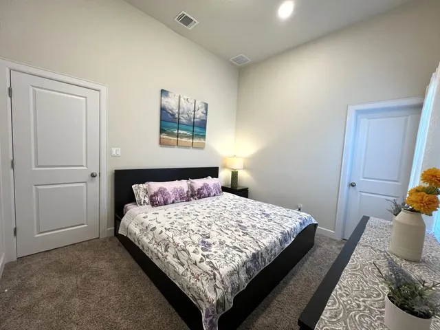 a bedroom with a bed and painting on the wall