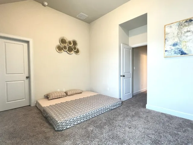 a bedroom with a bed and a painting on the wall