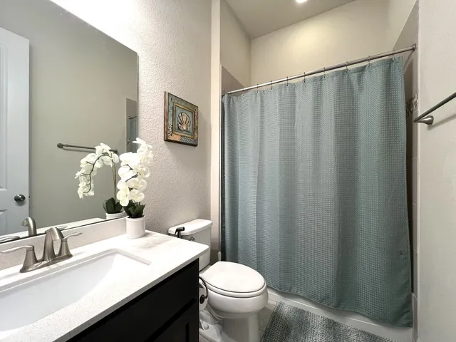 a bathroom with a granite countertop sink toilet and a mirror