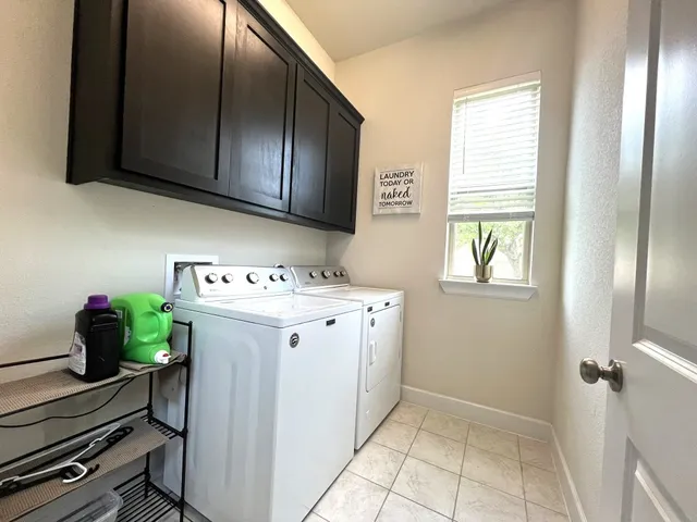 a utility room with cabinets washer and dryer