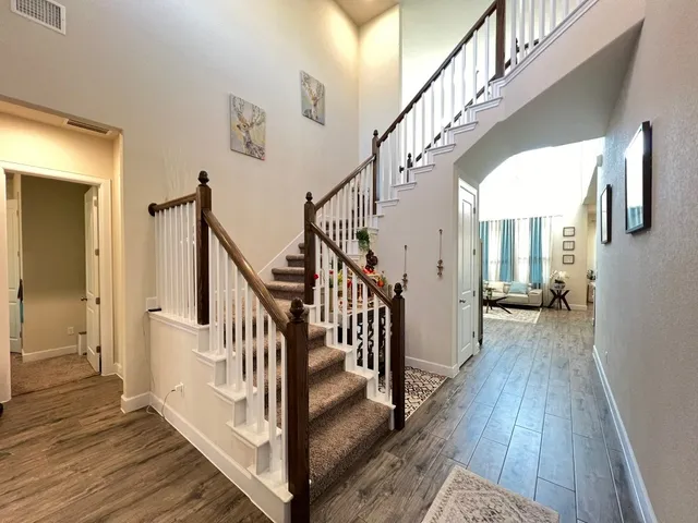 a view of staircase with wooden floor and a chandelier