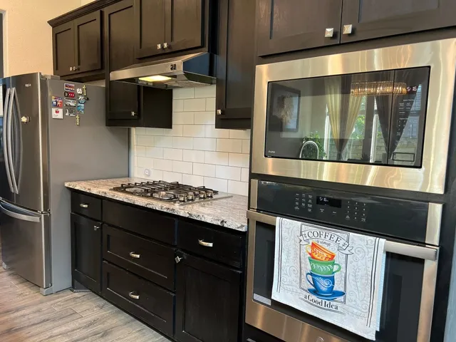 a kitchen with stainless steel appliances granite countertop a stove and a refrigerator