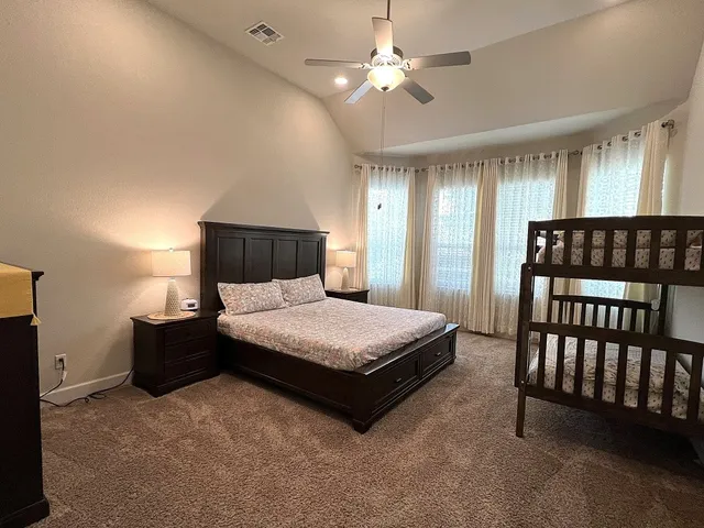a spacious bedroom with a bed and a chandelier