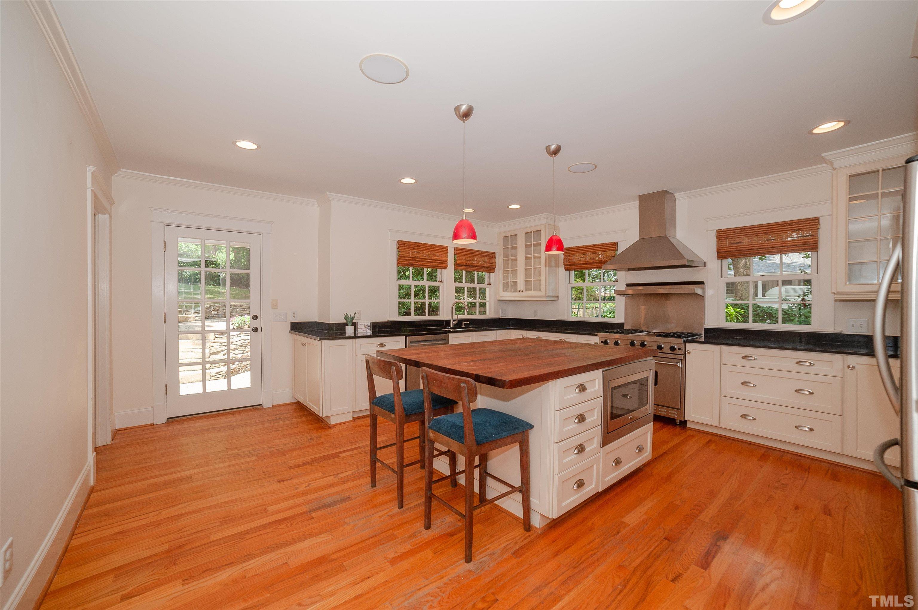 513 Gardner Street Raleigh, NC 27607 - Photo 13 of 56 a kitchen with stainless steel appliances granite countertop a stove a sink dishwasher and a refrigerator with wooden floor