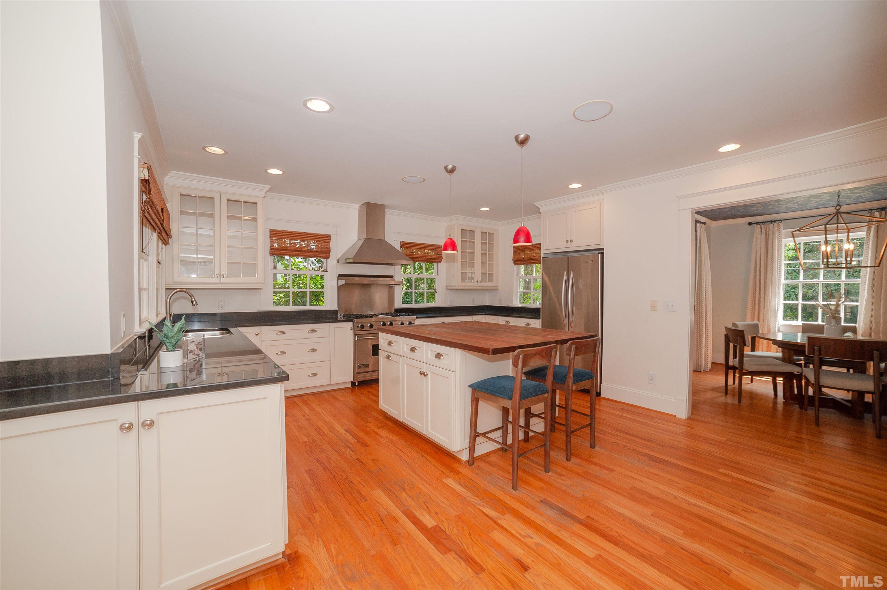 513 Gardner Street Raleigh, NC 27607 - Photo 14 of 56 a kitchen with stainless steel appliances granite countertop a sink cabinets and wooden floor