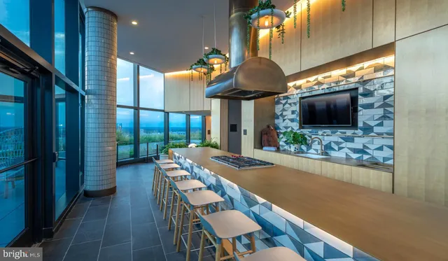 a kitchen with stainless steel appliances granite countertop a stove top oven a sink dishwasher a dining table and chairs with wooden floor