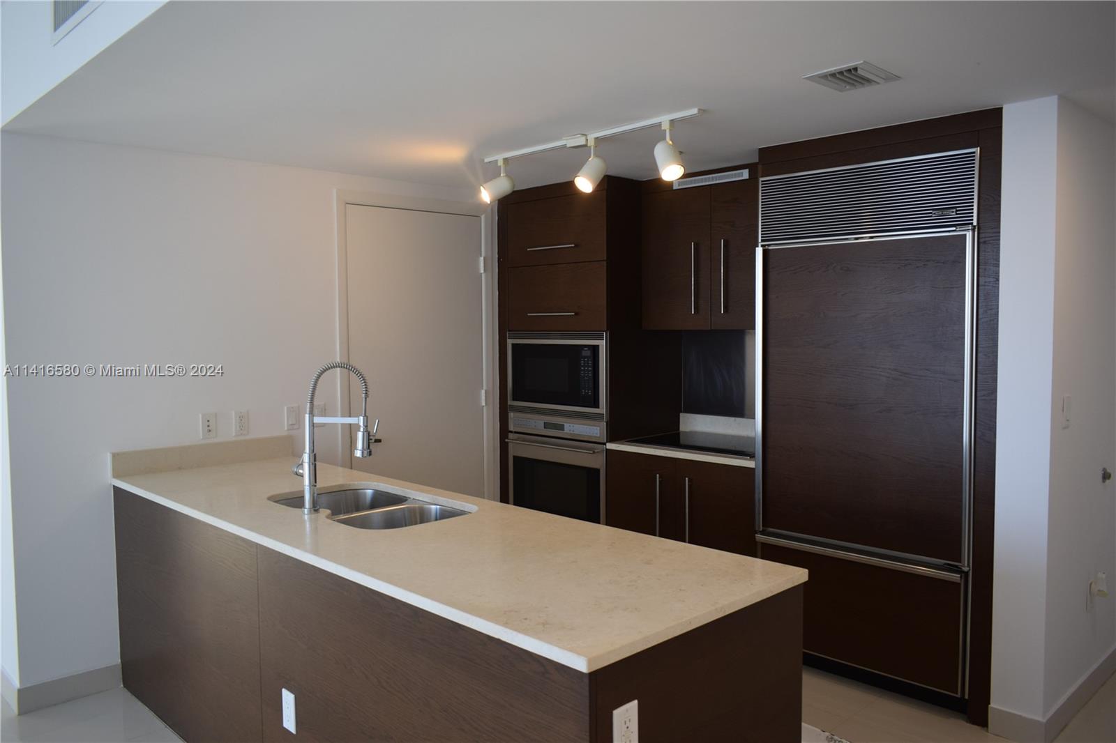 475 Brickell Avenue, Unit 4613 Miami, FL 33131 - Photo 10 of 30 a kitchen with a refrigerator and a sink