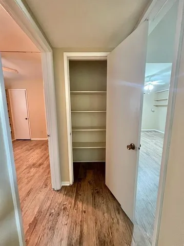 a view of a hallway with wooden floor and staircase