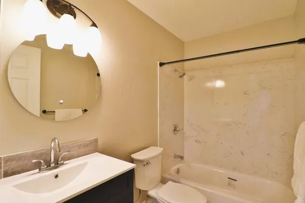 a bathroom with a sink mirror toilet and bathtub
