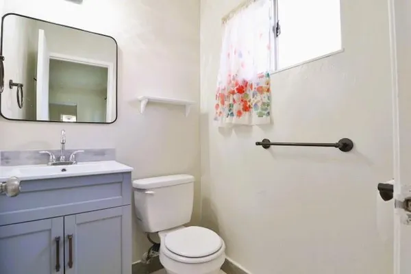 a bathroom with a toilet sink vanity and mirror
