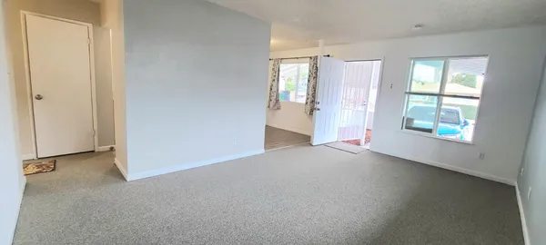 an empty room with windows and closet