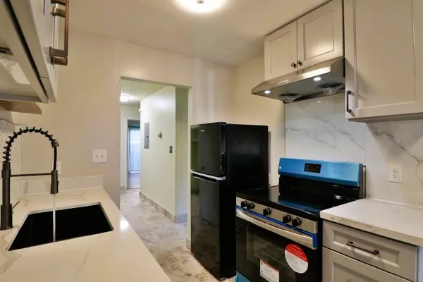 a kitchen with a refrigerator and a sink
