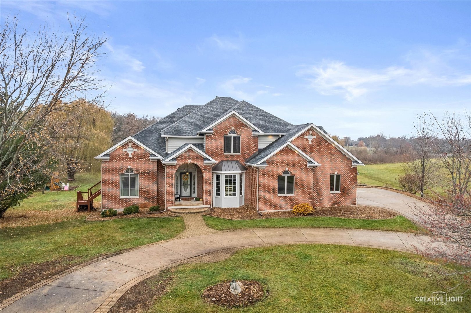 10167 East Deer Creek Lane Rochelle, IL 61068 - Photo 2 of 51 a front view of a house with a garden and trees