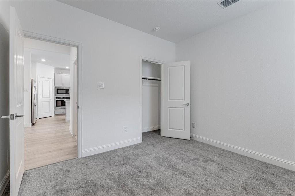 1433 Arciones Road Fort Worth, TX 76052 - Photo 13 of 33 an empty room with a cabinet and a refrigerator
