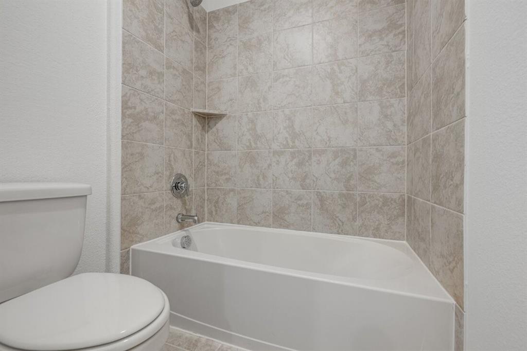 1433 Arciones Road Fort Worth, TX 76052 - Photo 17 of 33 a white bath tub sitting next to a white toilet