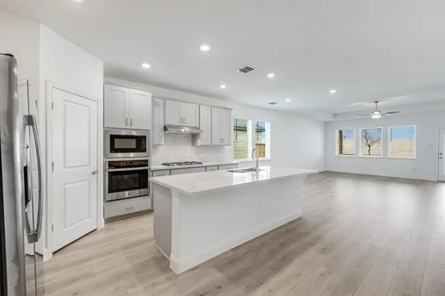 a kitchen with white cabinets and white appliances