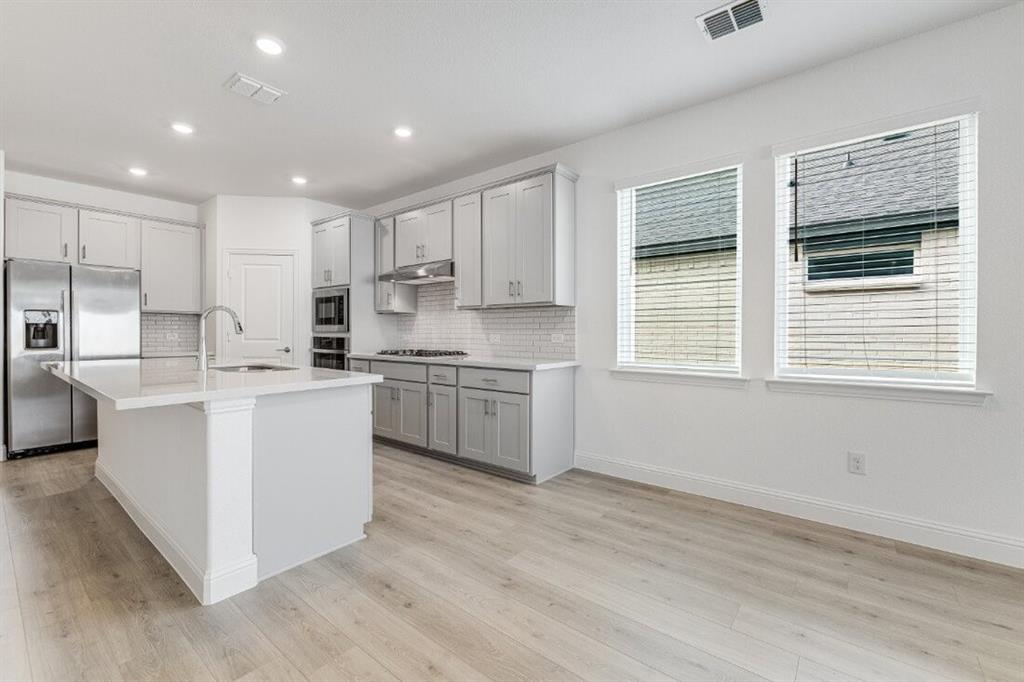 1433 Arciones Road Fort Worth, TX 76052 - Photo 8 of 33 a kitchen with white cabinets and white appliances