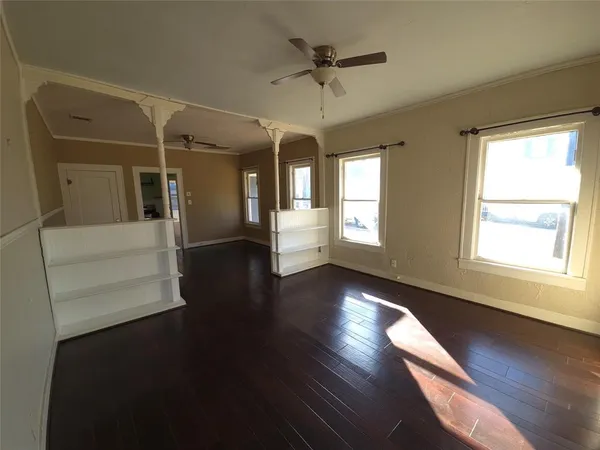 a view of a hallway with wooden floor and a living room