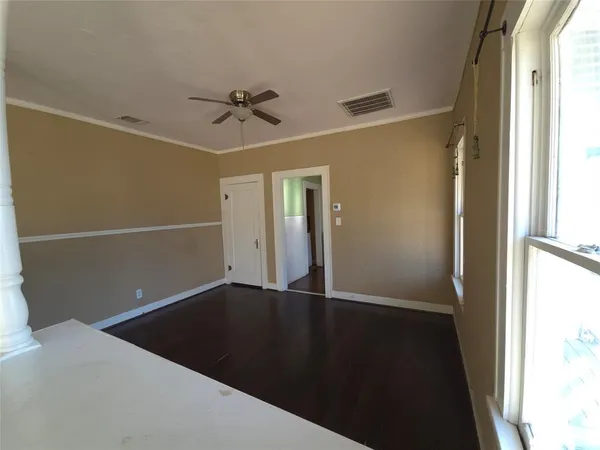 a view of empty room with wooden floor