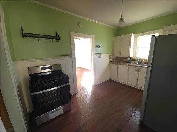 a kitchen with granite countertop a refrigerator a sink and dishwasher
