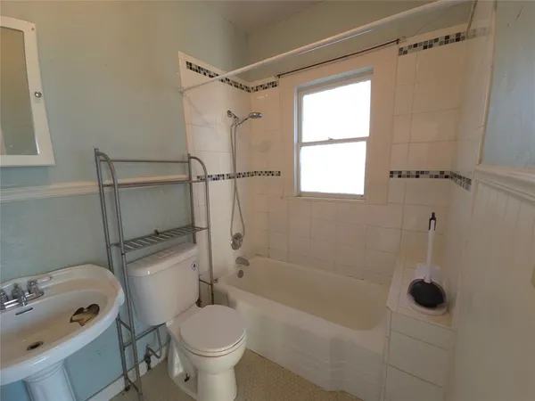 a bathroom with a bathtub toilet and shower