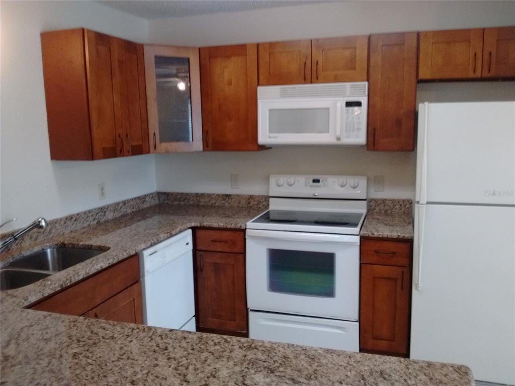 457 Hemlock Street Altamonte Springs, FL 32714 - Photo 3 of 15 a kitchen with stainless steel appliances granite countertop a stove a microwave and a sink