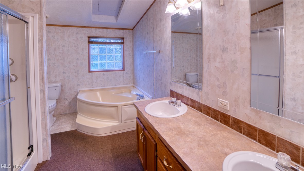 6063 Rudd Road Ashtabula, OH 44004 - Photo 5 of 17 Bathroom with a bath, a stall shower, crown molding, double vanity, and wallpapered walls