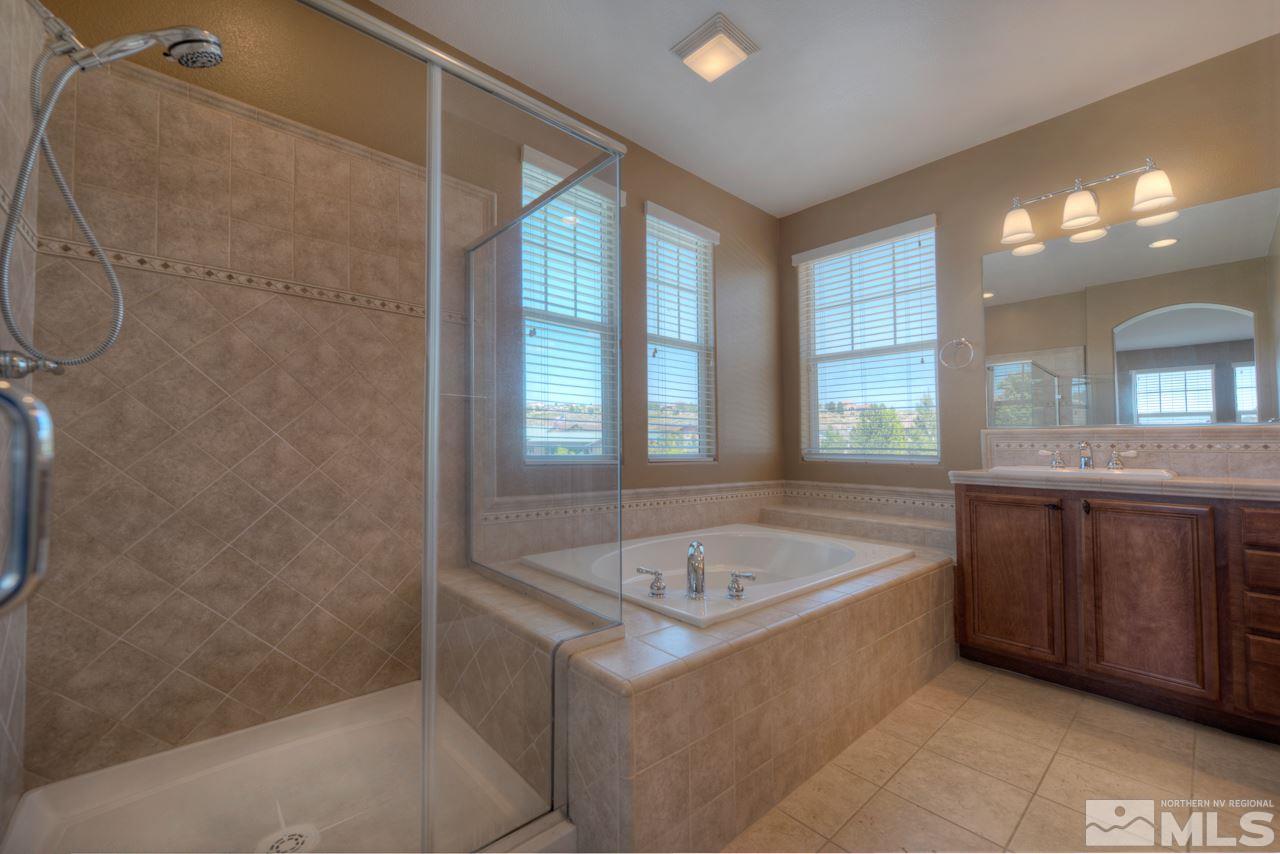 7781 Shalestone Way Reno, NV 89523 - Photo 11 of 24 a bathroom with a tub sink and mirror