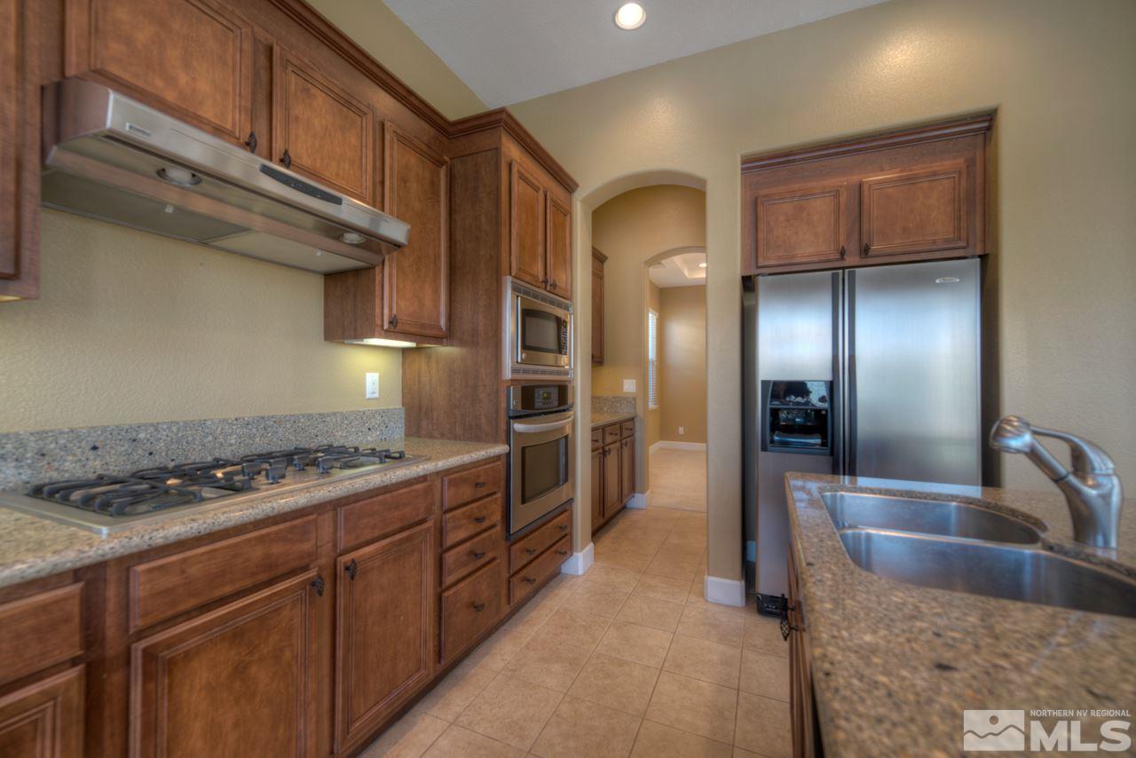 7781 Shalestone Way Reno, NV 89523 - Photo 2 of 24 a kitchen with stainless steel appliances granite countertop a sink a stove and a refrigerator