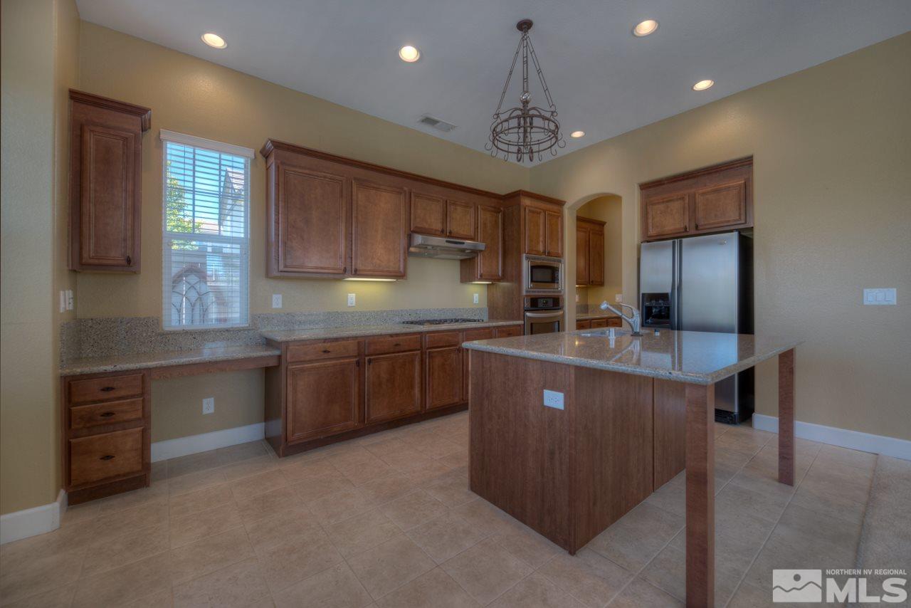7781 Shalestone Way Reno, NV 89523 - Photo 3 of 24 a kitchen with kitchen island granite countertop stainless steel appliances stove sink and cabinets