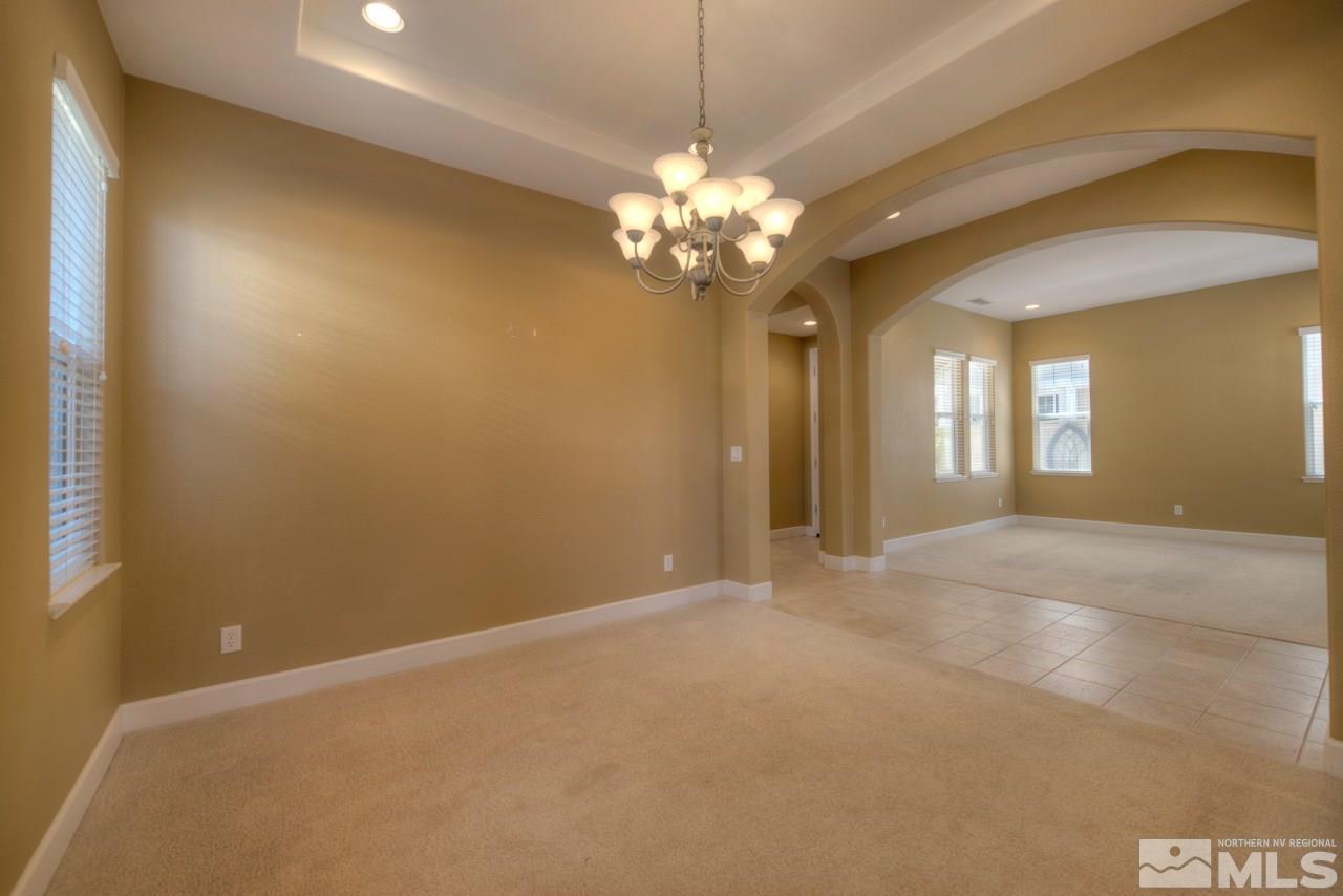 7781 Shalestone Way Reno, NV 89523 - Photo 9 of 24 a view of a chandelier with a chandelier fan and windows