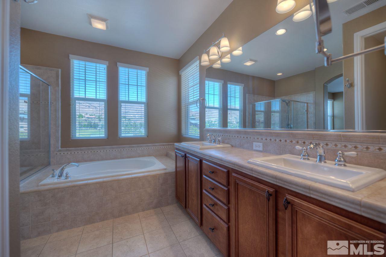 7781 Shalestone Way Reno, NV 89523 - Photo 10 of 24 a spacious bathroom with a granite countertop tub sink and mirror