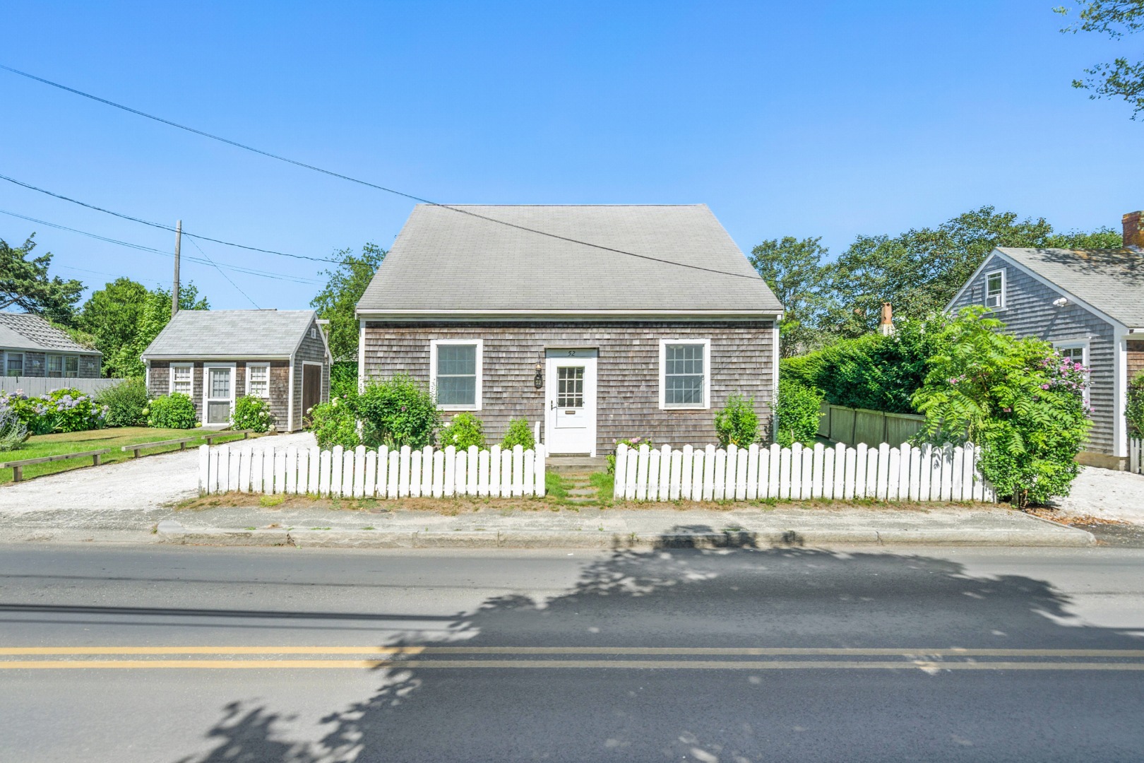 52 Pleasant Street Nantucket, MA 02554 - Photo 3 of 36 a front view of a house with a garden and plants