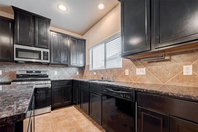 a kitchen with granite countertop stainless steel appliances and sink